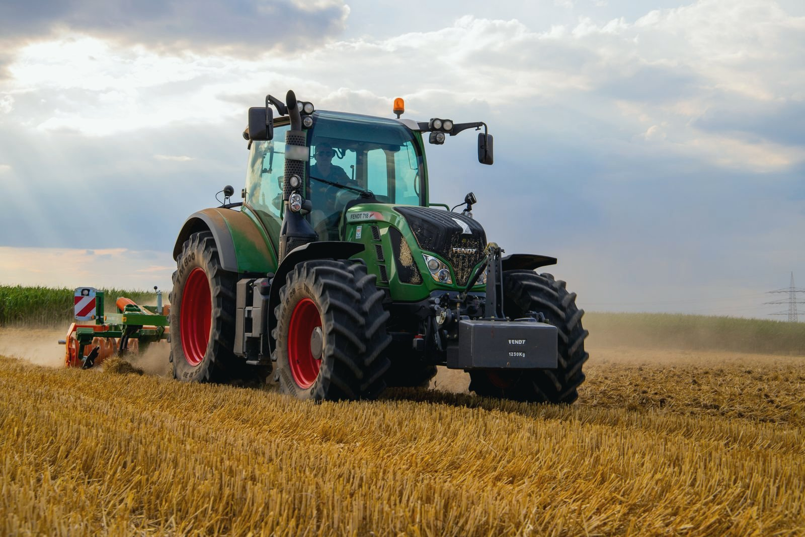 Farm tractors and sprayer near a rural Alberta fuel storage area